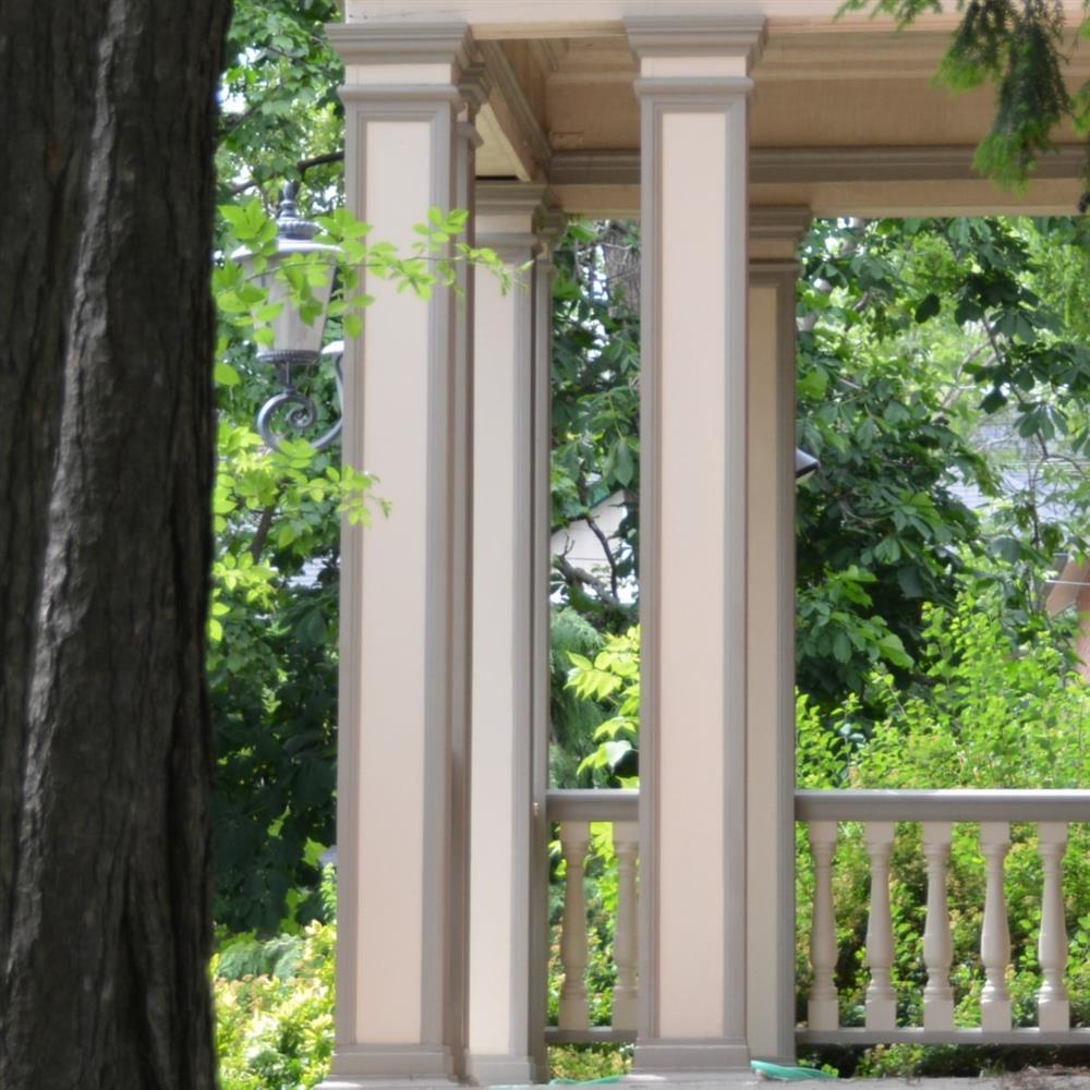 rectangular wooden columns with trim detail, white and grey, on a porch
